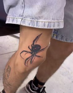 a man with a spider tattoo on his leg