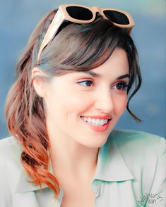 a woman wearing sunglasses and smiling at the camera