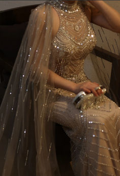 a woman sitting on a bench wearing a dress and holding a cell phone in her hand