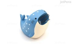 a blue and white whale shaped toothbrush holder on a white background with the words let's pens written below it