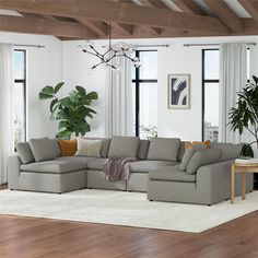 a living room with a large sectional couch in the middle and a potted plant next to it