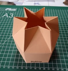 an origami vase sitting on top of a cutting board