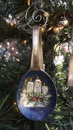 an ornament hanging from a christmas tree decorated with candles and snowflakes