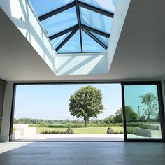 an empty room with large windows and a skylight