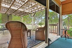 a porch with wicker furniture and blue carpet