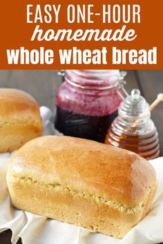 two loafs of bread sitting on top of a white cloth next to honey jars