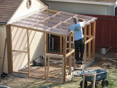 a man standing on top of a ladder next to a small building with a roof