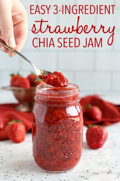 strawberry chia seed jam in a mason jar with a spoon and strawberries on the side