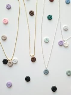 three necklaces with different letters on them and one has a small letter in the middle