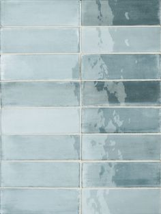 a tile wall that has been painted blue and gray