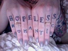 a woman with tattoos on her hands holding up two fingers that say homeless and remain