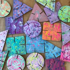 paper plates with different designs on them sitting on top of a wooden table next to scissors