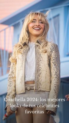 a woman with blonde hair wearing a leopard print jacket and tan pants, smiling at the camera