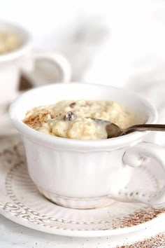 two white cups filled with oatmeal sitting on top of a plate