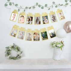 a mantle topped with pictures and balloons next to a white vase filled with greenery