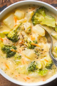 a white bowl filled with broccoli and cheese soup on top of a wooden table