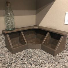 an empty bottle sitting on top of a counter next to a shelf filled with glass bottles