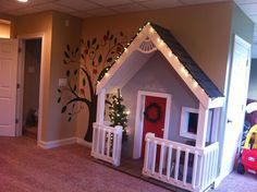 a dog house is in the middle of a living room with stairs leading up to it