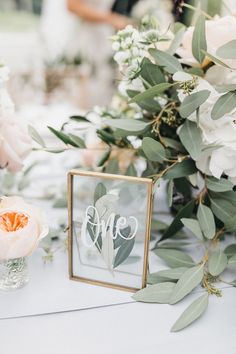 the table is set with flowers and greenery