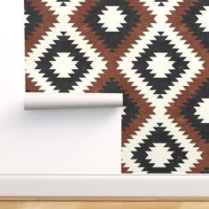 a brown and white wallpaper with black and white geometric design on the wall next to a wooden floor