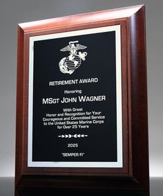 an award plaque is displayed on a black and wood frame with white border around it