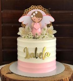 a white and pink cake with an angel on top