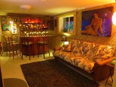 a living room filled with furniture and a painting on the wall above it's bar