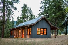 a small blue cabin in the woods at dusk