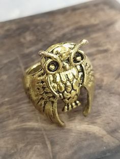 an owl ring sitting on top of a wooden table