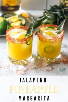 two glasses filled with pineapple margaritas on top of a table