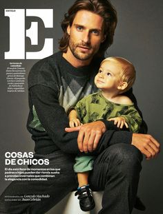 a man holding a baby in his arms on the cover of an issue of magazine