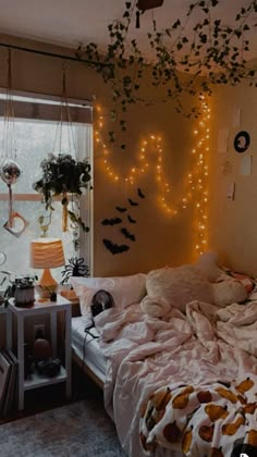 an unmade bed sitting next to a window in a room with lights on the wall