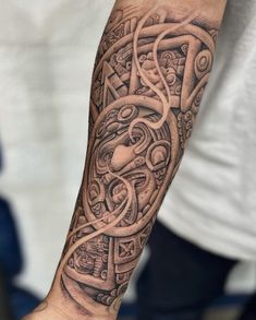 a man's arm with an intricate tattoo design on the forearm and hand,