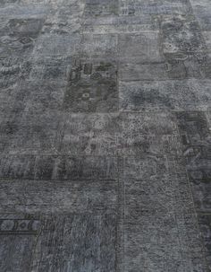 an area rug with many different designs and colors on the floor, including gray carpeting