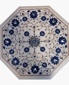 a decorative blue and white plate with flowers on the inside is shown in this image