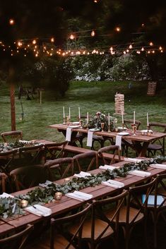 tables set up with candles and greenery for an outdoor dinner