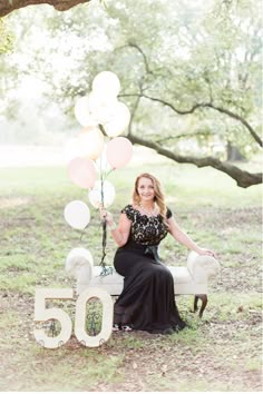 a woman sitting on a bench with balloons in her hand and the number 50 spelled out