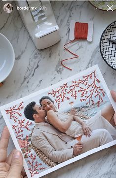 two hands holding a card with an image of a man and woman in love on it