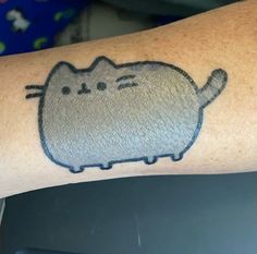 a cat tattoo on the arm of a person's left arm, which is drawn in black ink