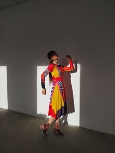 a woman standing in front of a white wall