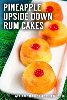 three pineapple upside down rum cakes on a white plate with green grass in the background