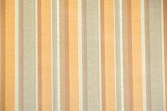 an orange and beige striped wallpaper with vertical stripes on it's surface,