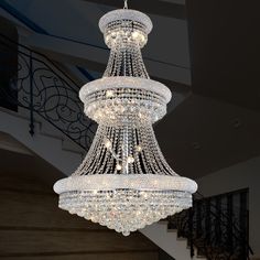 a large crystal chandelier hanging from the ceiling in a room with staircases