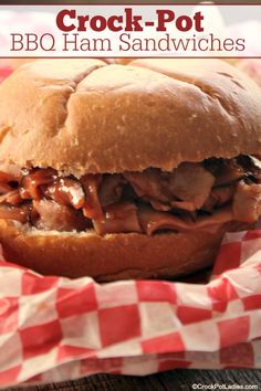 a close up of a sandwich on a table with red and white checkered paper