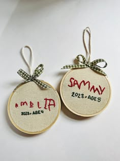 two personalized christmas ornaments hanging from twine