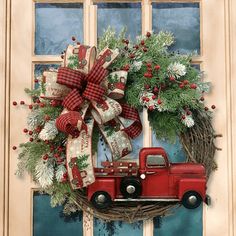 a red truck is parked in front of a door with a wreath on the side