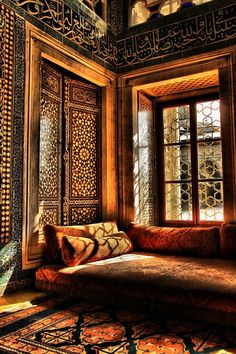 a couch sitting in front of a window next to a rug