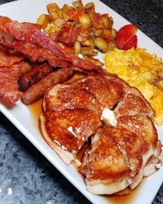 pancakes, bacon, and scrambled eggs on a white plate