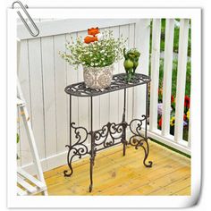 an iron plant stand with flowers on it