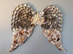 an angel made out of shells and seashells on a wall with a starfish